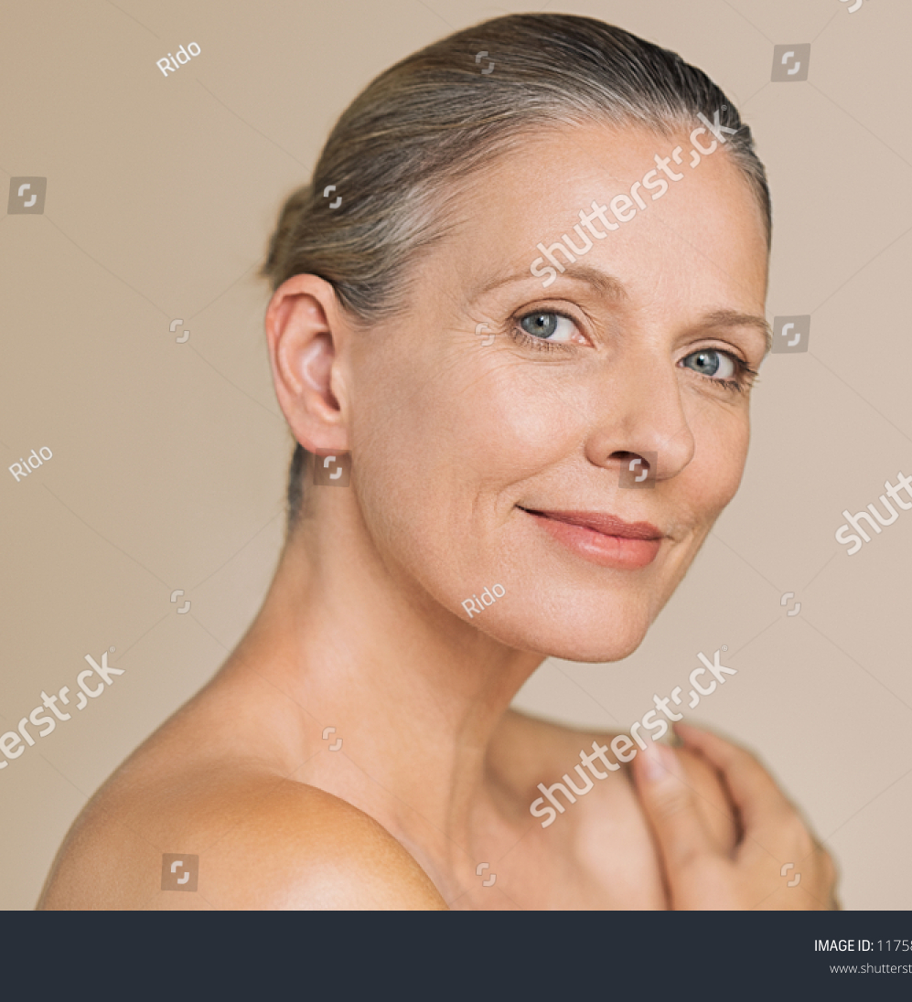 stock-photo-smiling-senior-woman-with-bun-hair-and-hand-on-naked-shoulder-portrait-of-beauty-mature-woman-1175898607